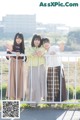 A group of young women standing next to each other near a fence.