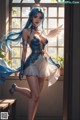 A woman with long blue hair standing in front of a window.