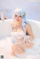 A woman sitting in a bathtub filled with foam.