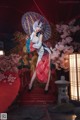 A woman in a red and white kimono holding an umbrella.