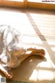 A woman laying on a mat in front of a window.