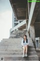 A woman sitting on the steps of an abandoned building.