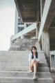 A woman sitting on the steps of an abandoned building.