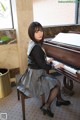 A woman sitting at a piano in a room.