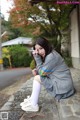 A woman sitting on the ground with a flower in her hand.