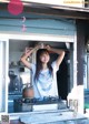 A woman standing in front of a stove in a kitchen.