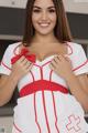 A woman in a white and red nurse outfit posing for a picture.